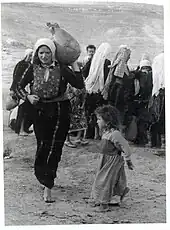 Palestinian woman, a child and a jug.