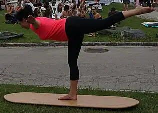 Virabhadrasana III: the balancing skill needed for Paddleboard Yoga can be practised on land on a balanceboard, a support designed to wobble as if on water.