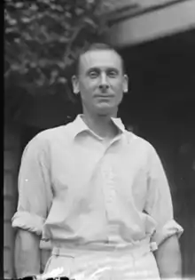 A man standing wearing cricket whites